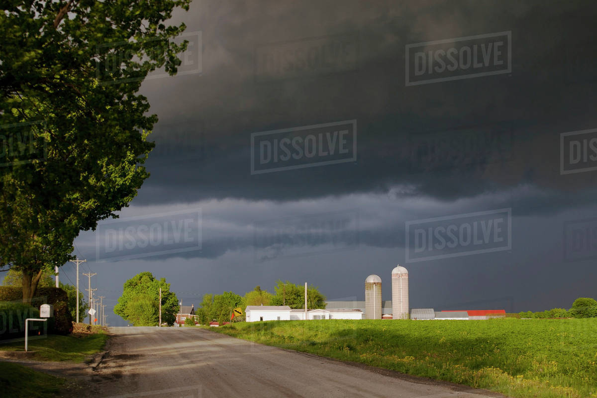 Storm Clouds Over A Farm; Farnham,Quebec, Canada Stock Photo Dissolve
