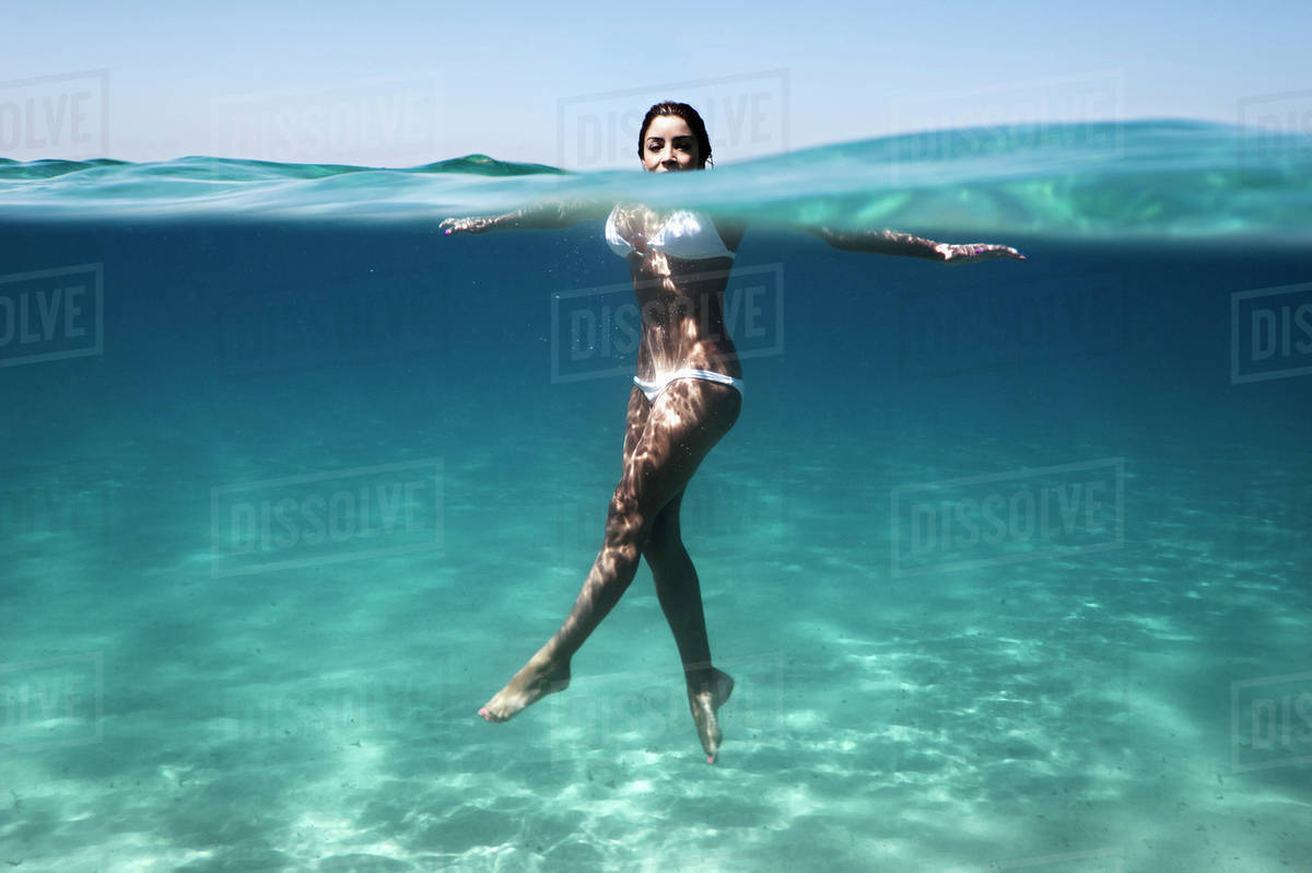 A Woman's Body Immersed In Water Wearing A Two Piece Bathing Suit
