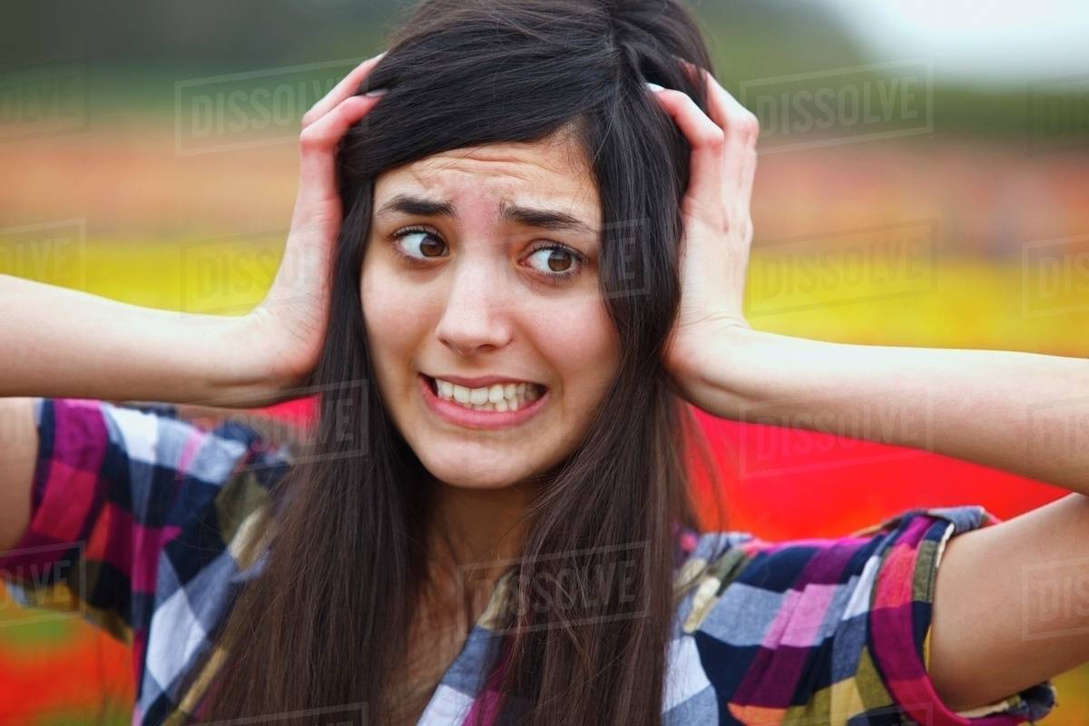 A Girl Holding Her Head With A Crazy Face Stock Photo Dissolve