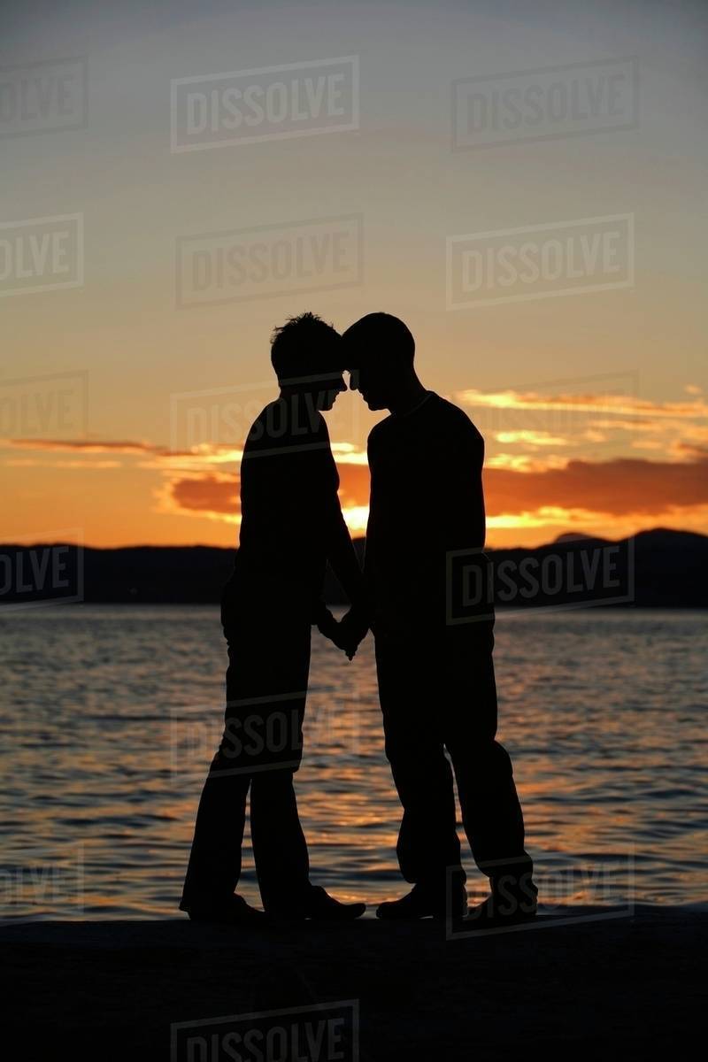 Couple Standing By The Water Stock Photo Dissolve