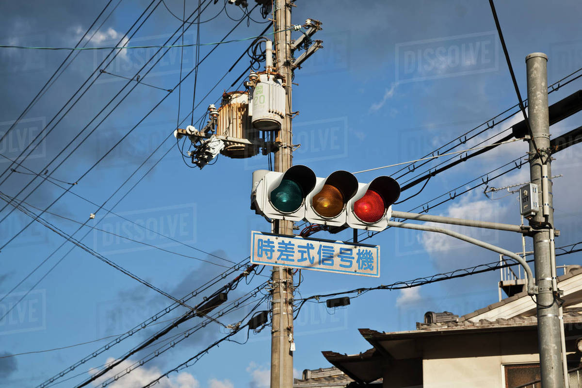 Traffic light with street sign and transmission lines; Kyoto, Japan