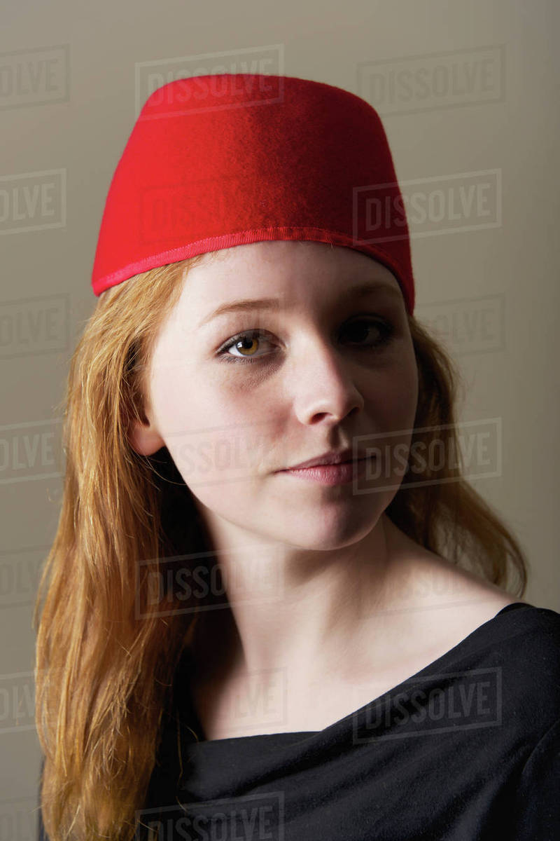 Portrait Of A Young Woman With Long Red Hair Wearing A Red Felt