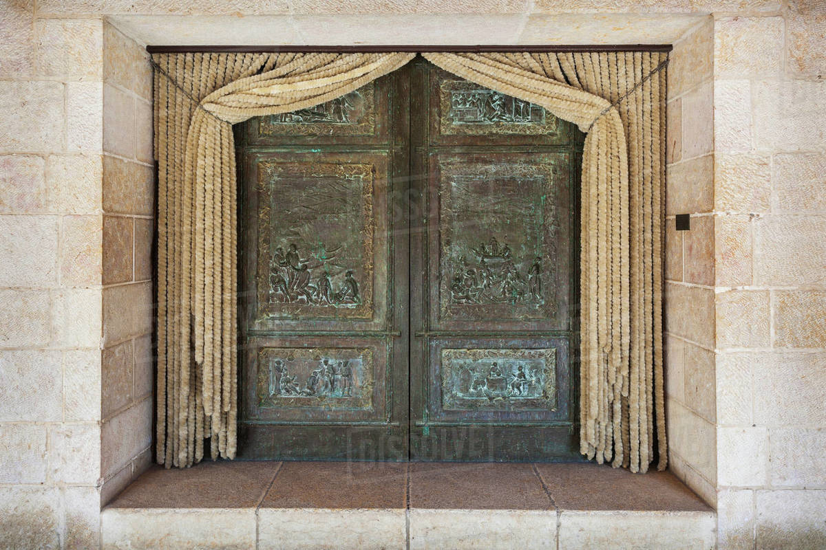 Double Doors With Green Facade And Curtains Pulled Back On A