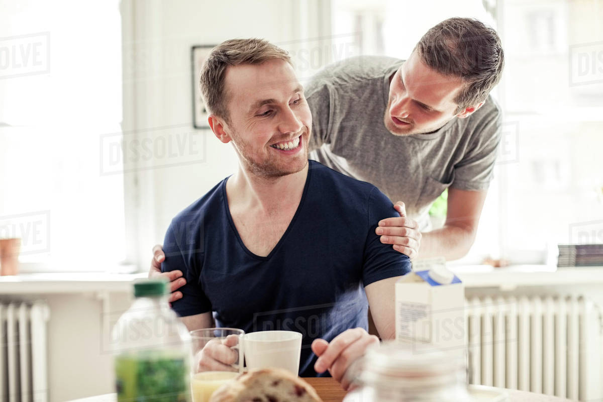Young Gay Man Looking At Partner While Having Breakfast In House Young Gay Man Looking At Partner While Having Breakfast In House