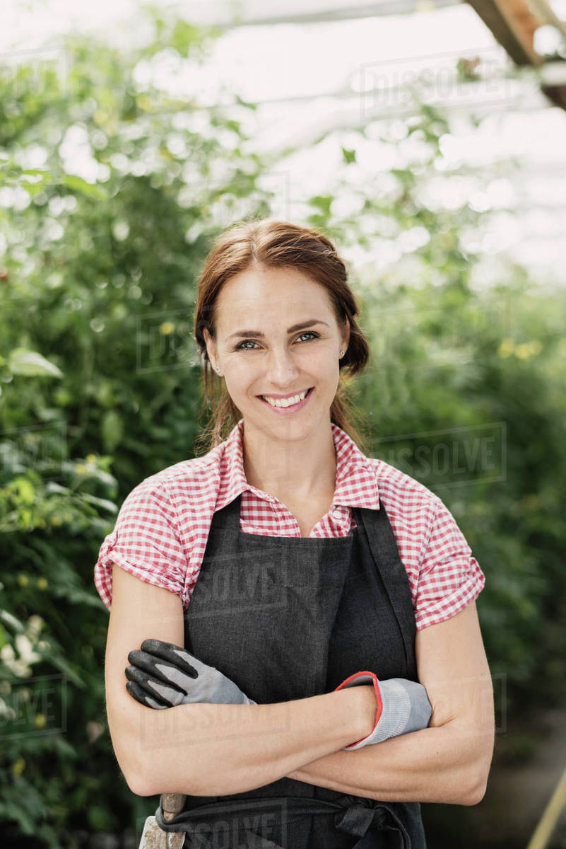 Portrait of smiling female gardener with arms crossed standing in