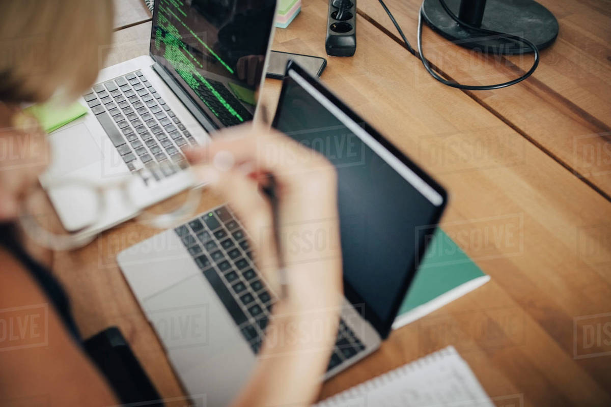 Cropped image of computer programmer working at desk in office ...