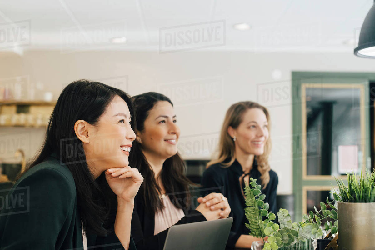 Smiling businesswomen sitting at conference table in meeting Royalty-free stock photo