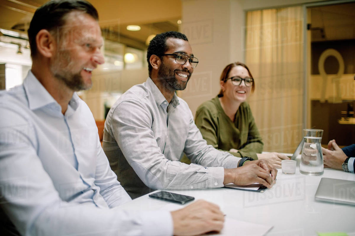 Sales executives smiling during business meeting at conference table in office Royalty-free stock photo