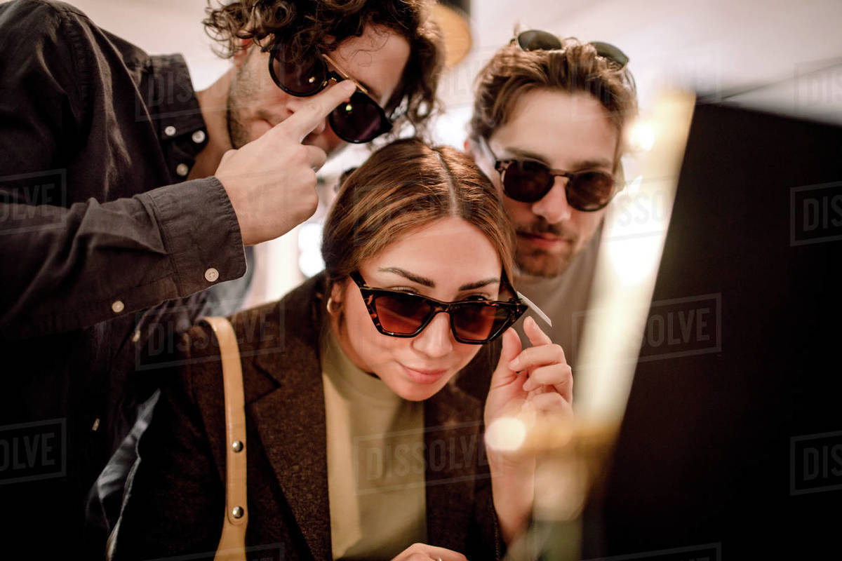 Smiling friends trying fashionable eyeglasses at store Royalty-free stock photo