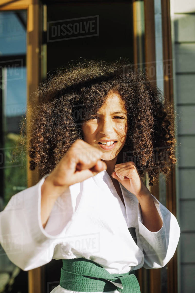 Portrait of girl doing martial arts at home Stock Photo Dissolve