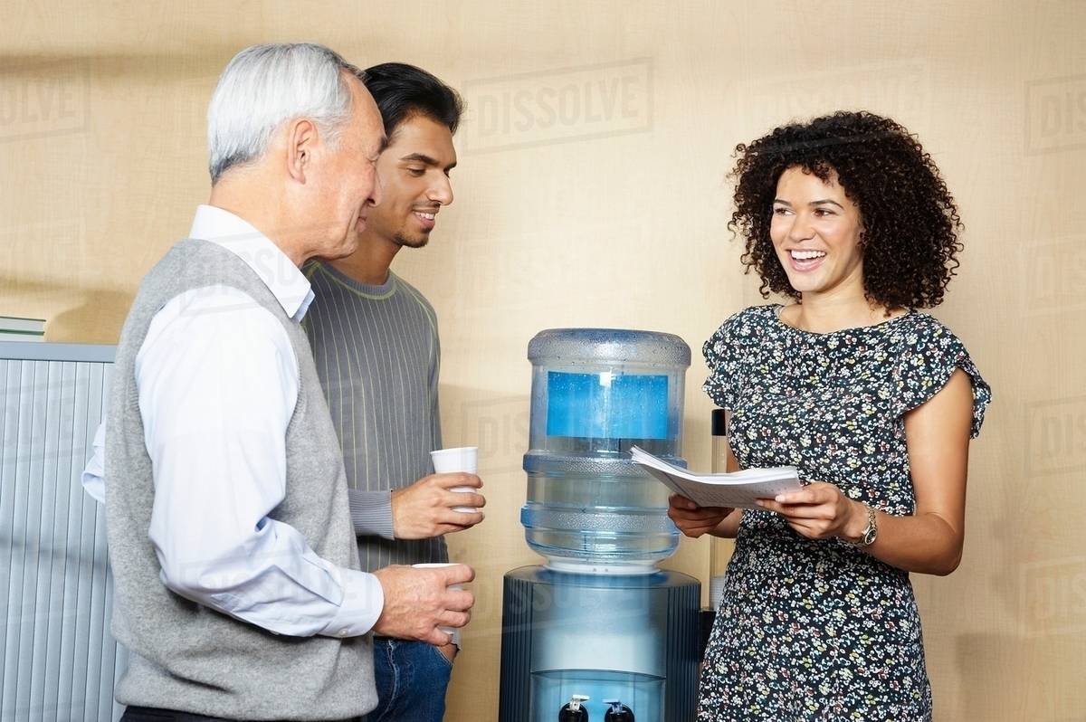 Casual meeting by office water cooler Stock Photo Dissolve