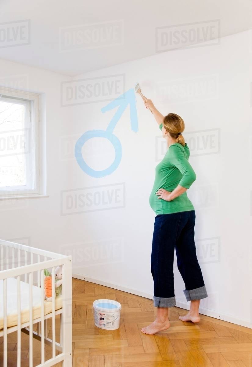 Pregnant woman painting nursery Stock Photo Dissolve