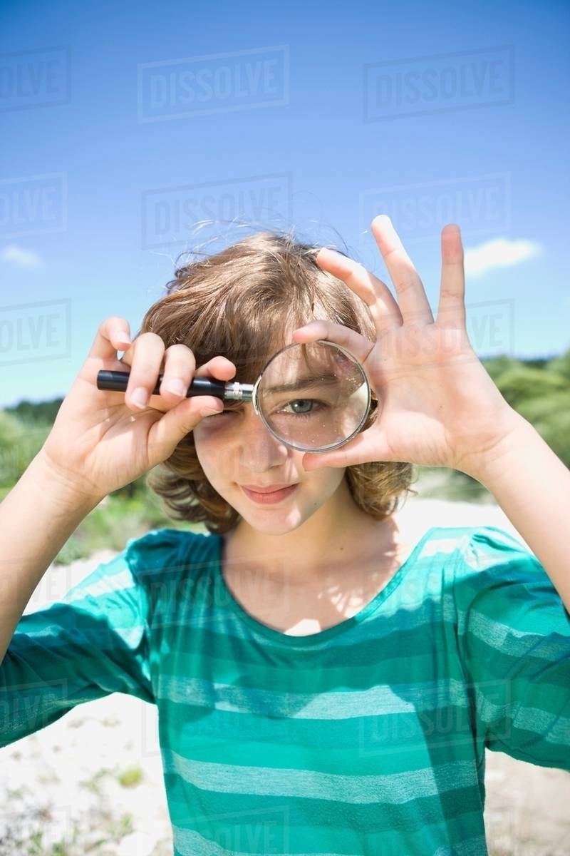 Girl looking through a loupe Stock Photo Dissolve
