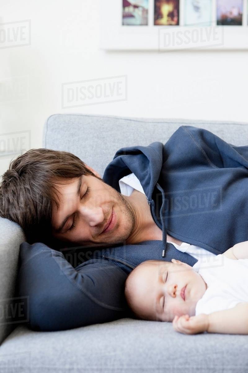 Father and baby sleeping on couch Stock Photo Dissolve