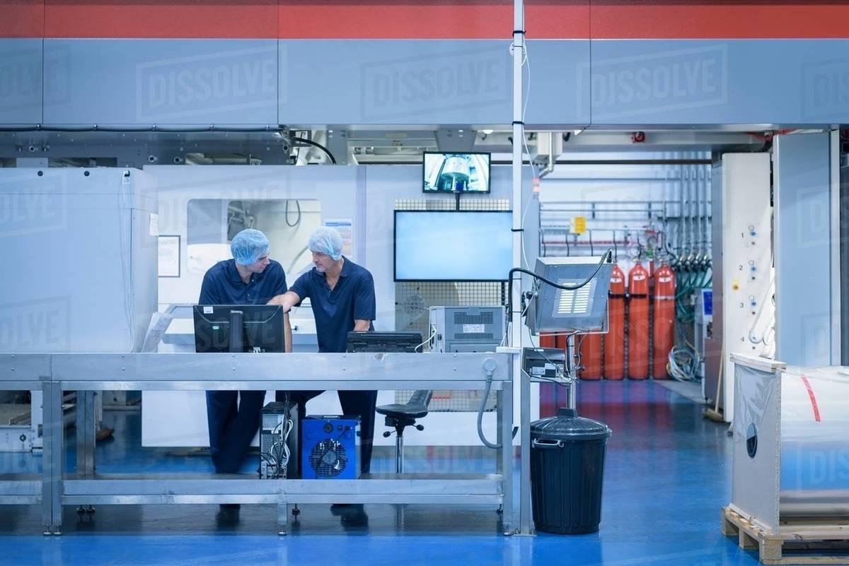 Workers with printing machine in food packaging printing factory