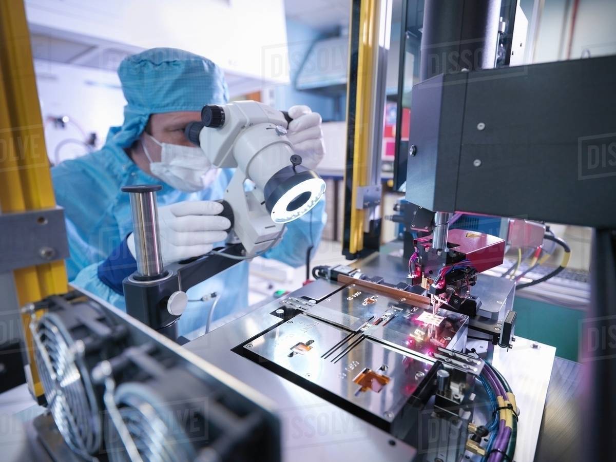 Electronics worker checking component in clean room Stock Photo