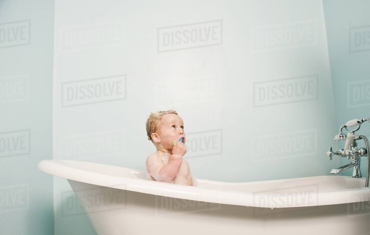 Toddler sitting in bubble bath Stock Photo Dissolve