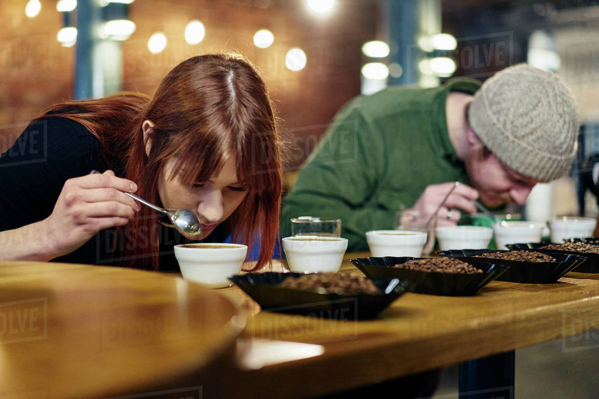 Coffee shop team smelling bowls of coffee and coffee beans at tasting
