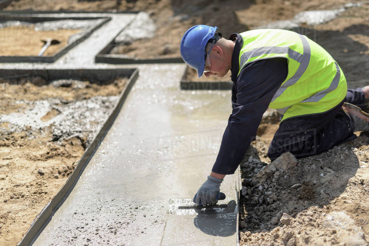apprentice builder laying concrete