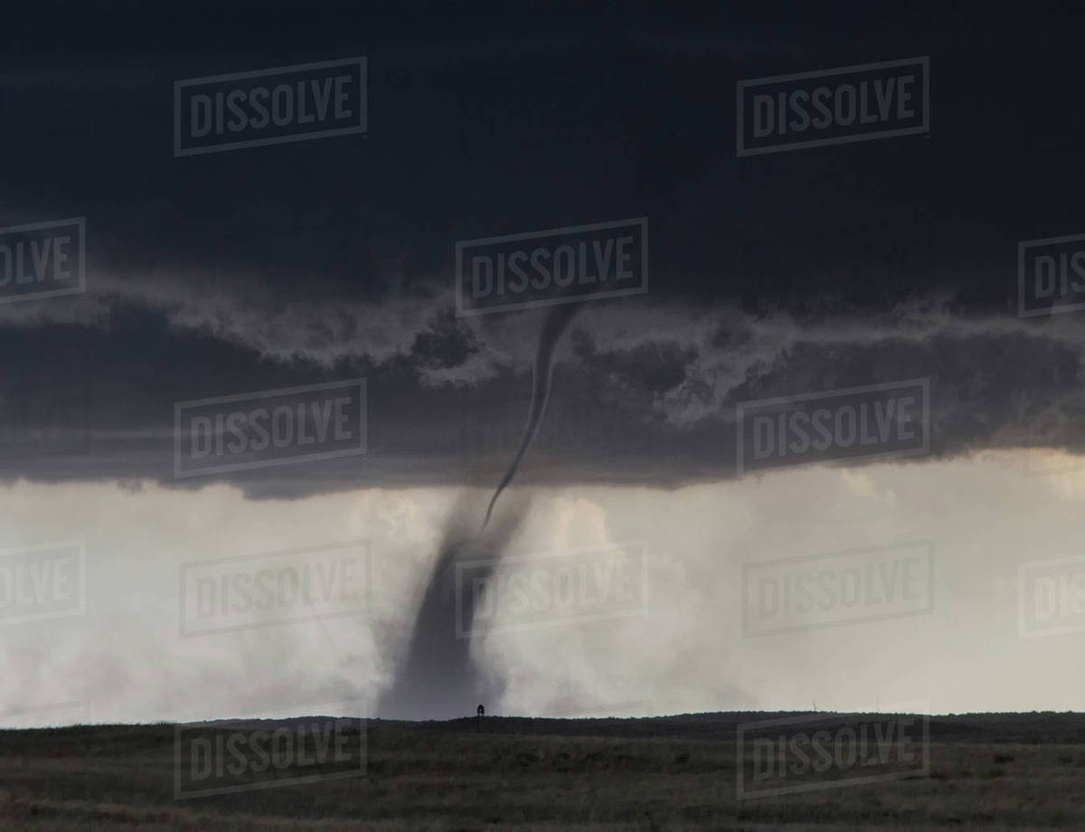 A needle shaped funnel reaches to the ground as this tornado forms over