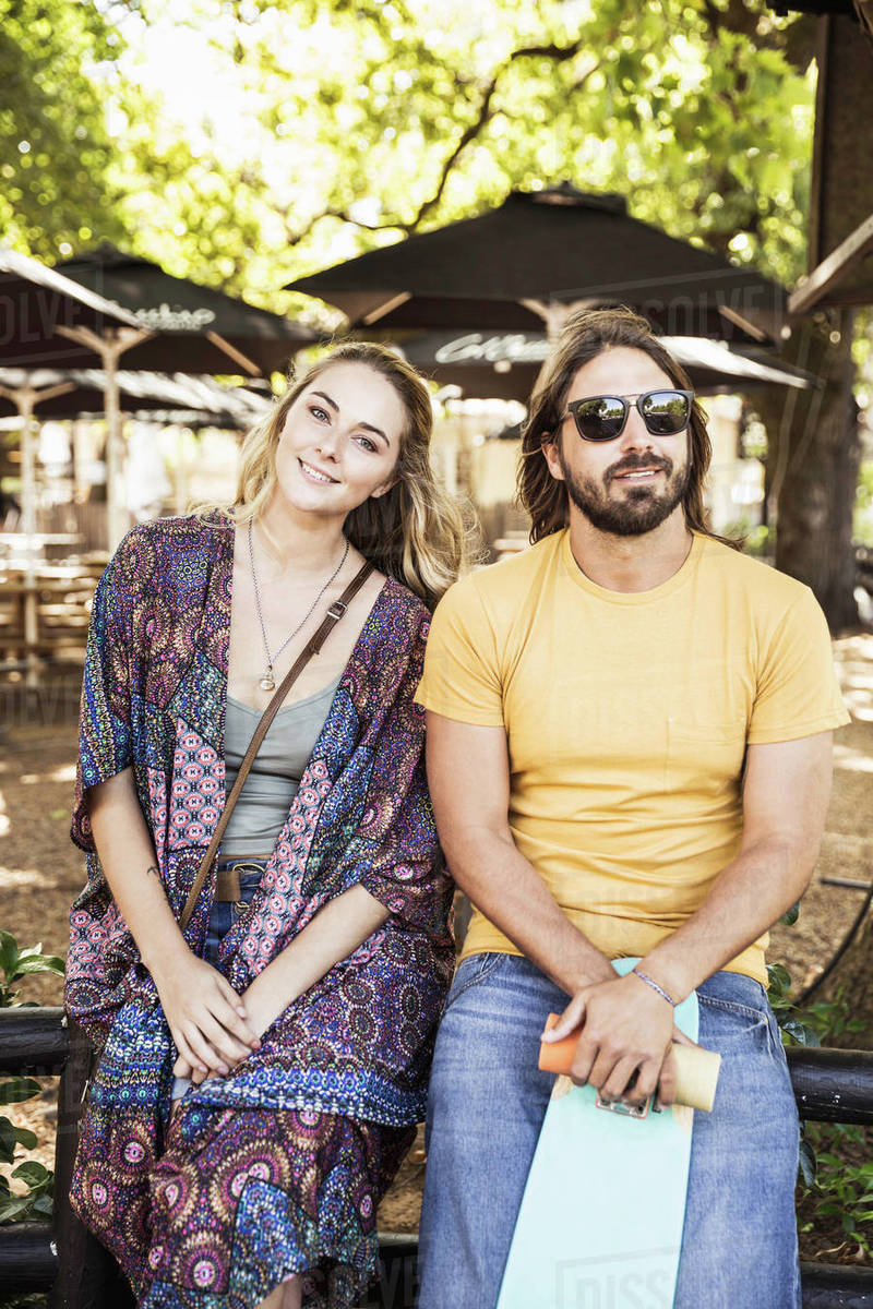 Couple sitting side by side looking at camera smiling Stock Photo