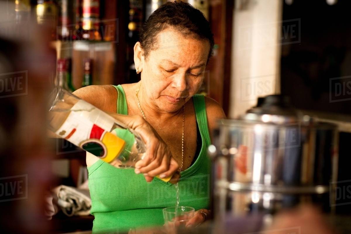 Woman serving liquor in bar Stock Photo Dissolve