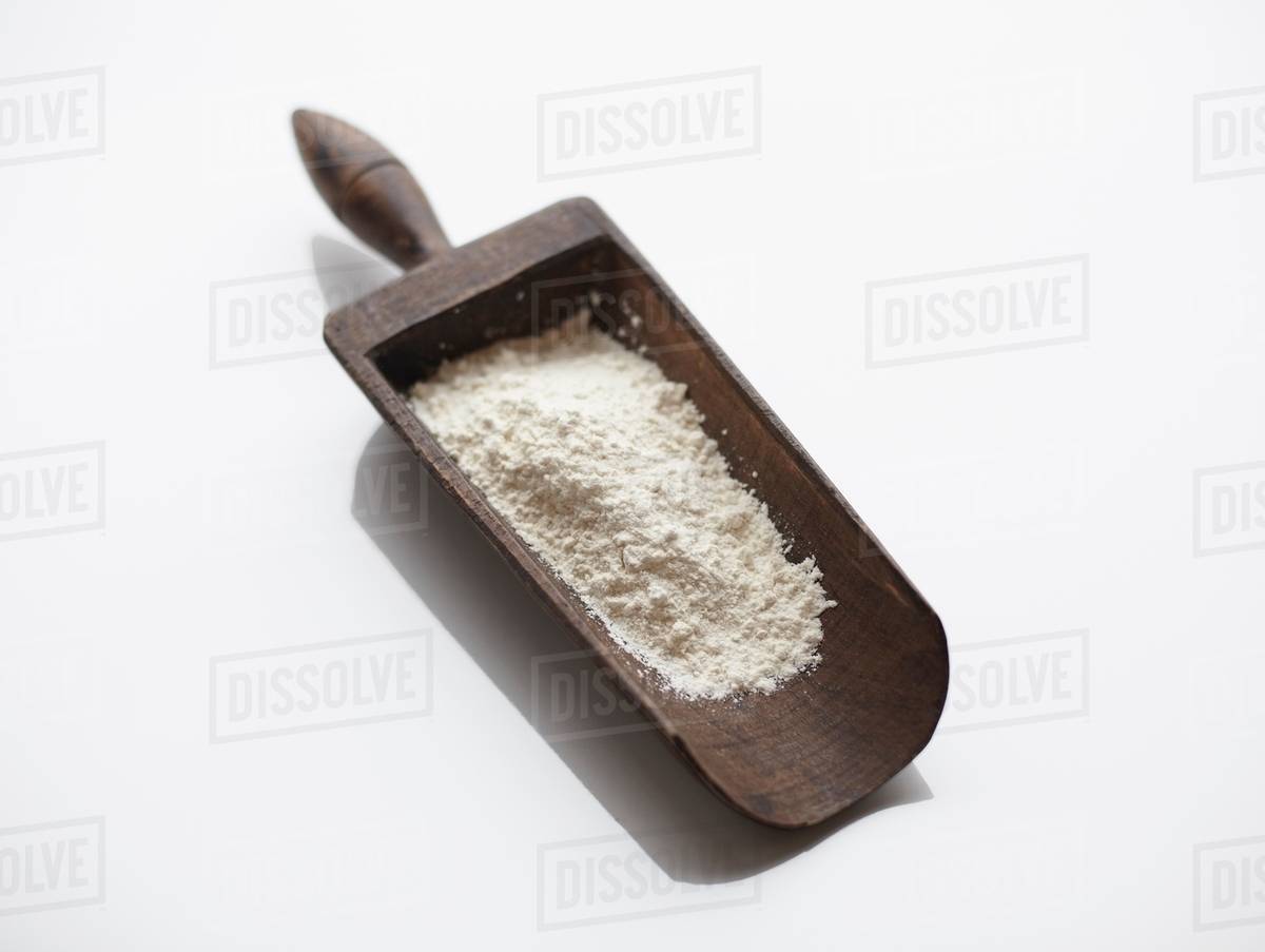 Flour in wooden scoop - Stock Photo - Dissolve