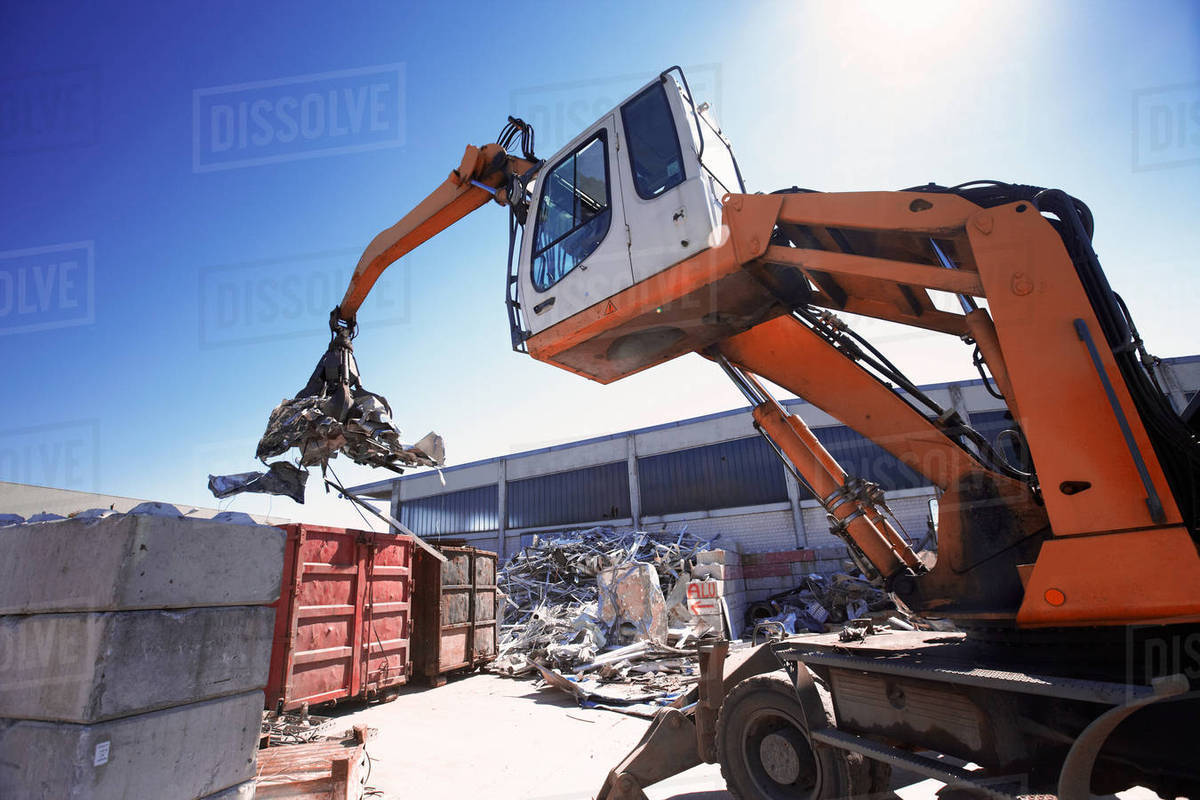 Grapple handler sorting and moving metals in scrap yard Stock Photo
