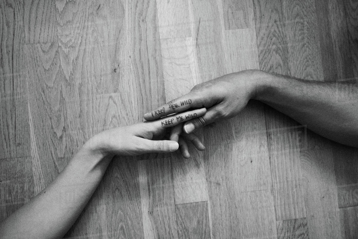 couple hands touching writing