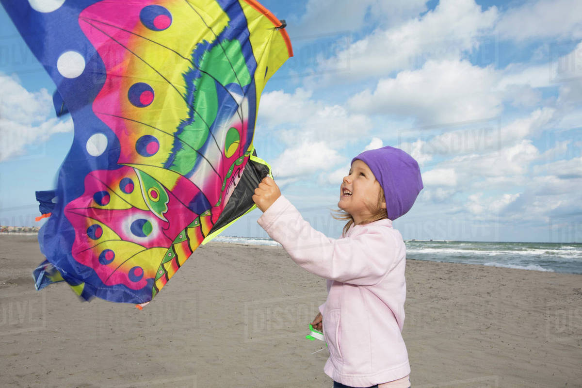 Girl flying kite on beach Stock Photo Dissolve