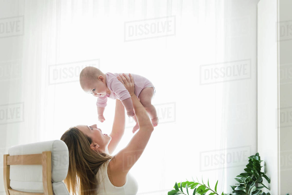 Mother lifting baby up Stock Photo Dissolve
