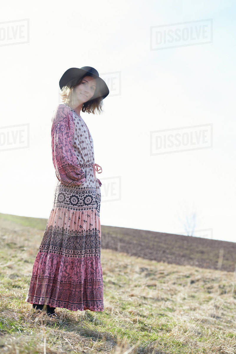 Hippy style woman wearing felt hat in field, portrait Stock Photo