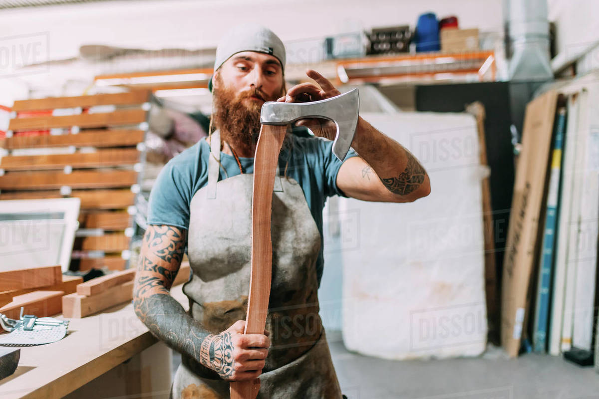 Axe maker fitting axe head to handle in Stock Photo Dissolve