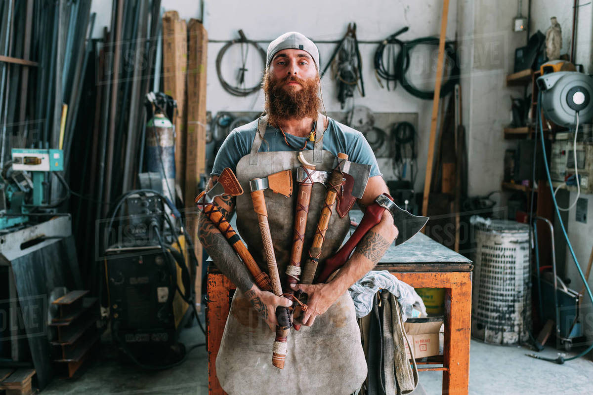Axe maker showing off variety of handcrafted axes Stock Photo Dissolve