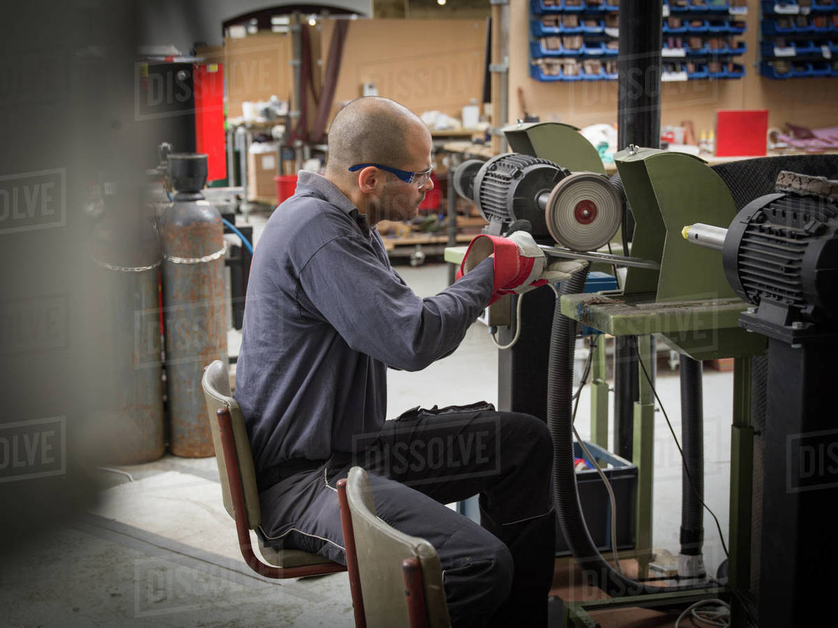 Knife factory worker using angle grinder in Stock Photo Dissolve
