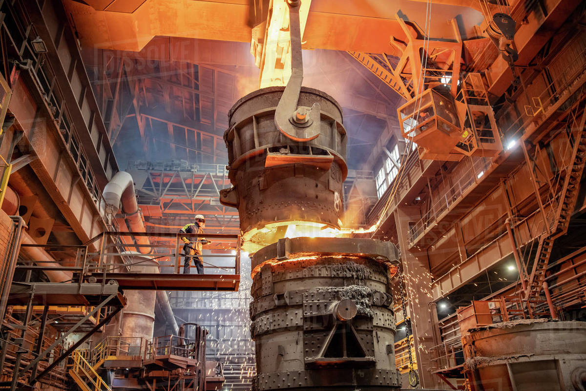 Steelworker starting molten steel pour in steelworks Royalty-free stock photo