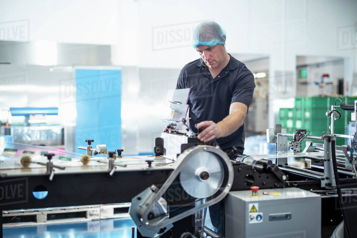 Worker adjusting printing machine in print factory Royalty-free stock photo