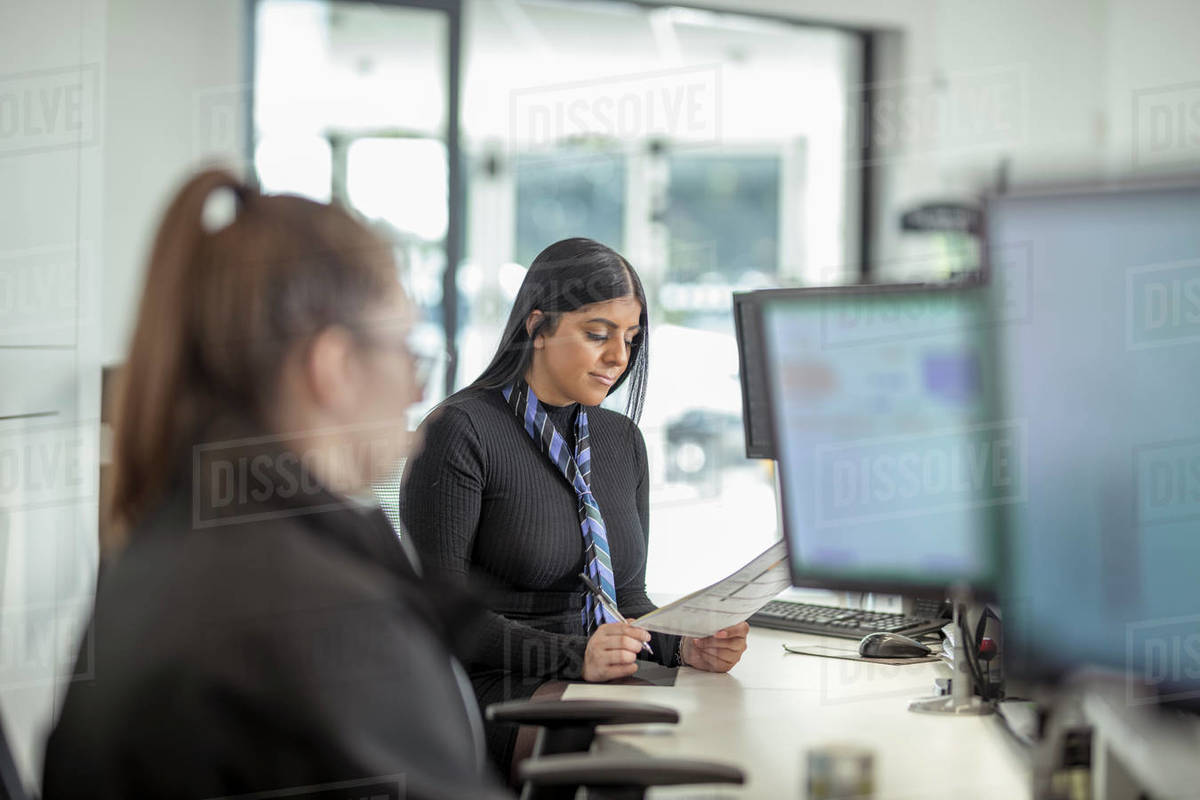 Female apprentice service advisors in car dealership Royalty-free stock photo