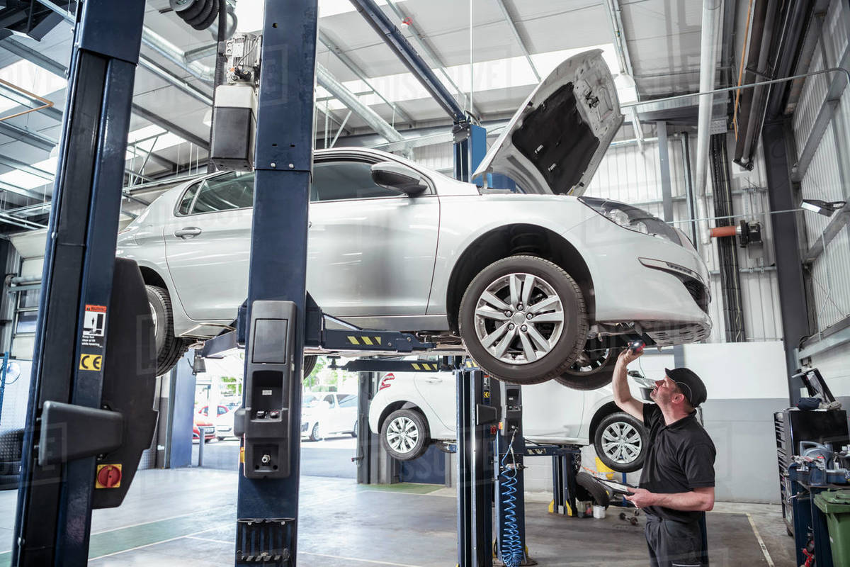 Engineer checking car on ramp in car service centre Royalty-free stock photo
