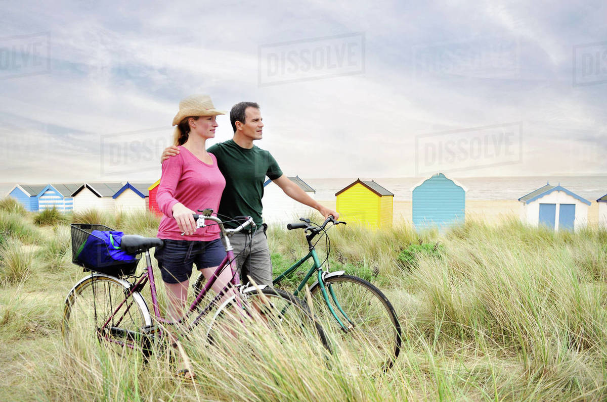 Mid adult couple with bicycles at coast, Southwold, Suffolk, UK Royalty-free stock photo