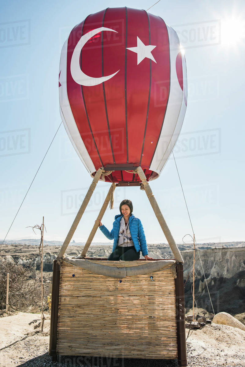 Woman sitting on basket of hot air balloon overlooking fairy chimney valley, Göreme, Cappadocia, Nevsehir, Turkey Royalty-free stock photo