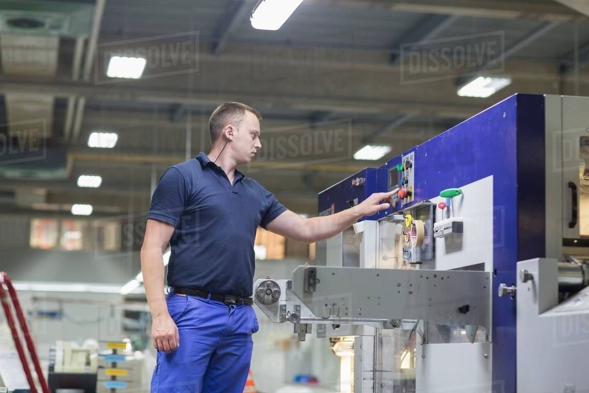 Worker using machine in paper packaging factory Stock Photo Dissolve