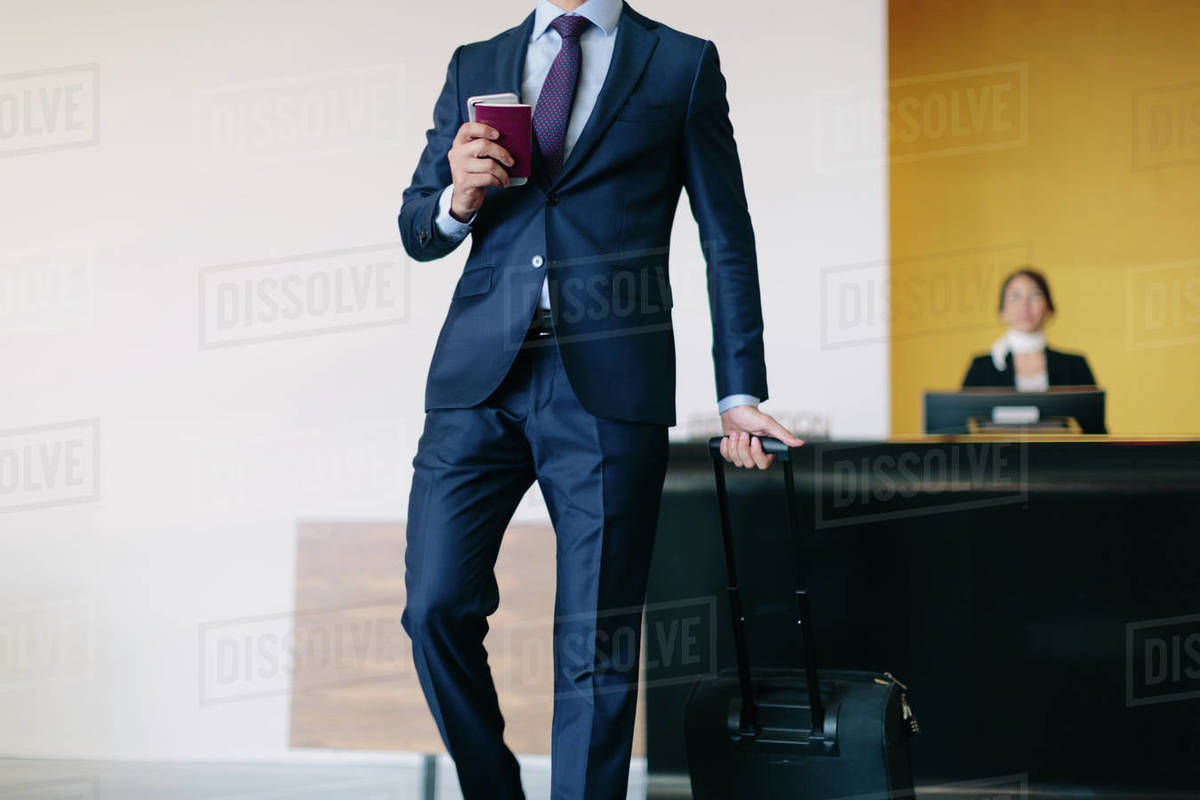 Businessman checking out of hotel Stock Photo Dissolve
