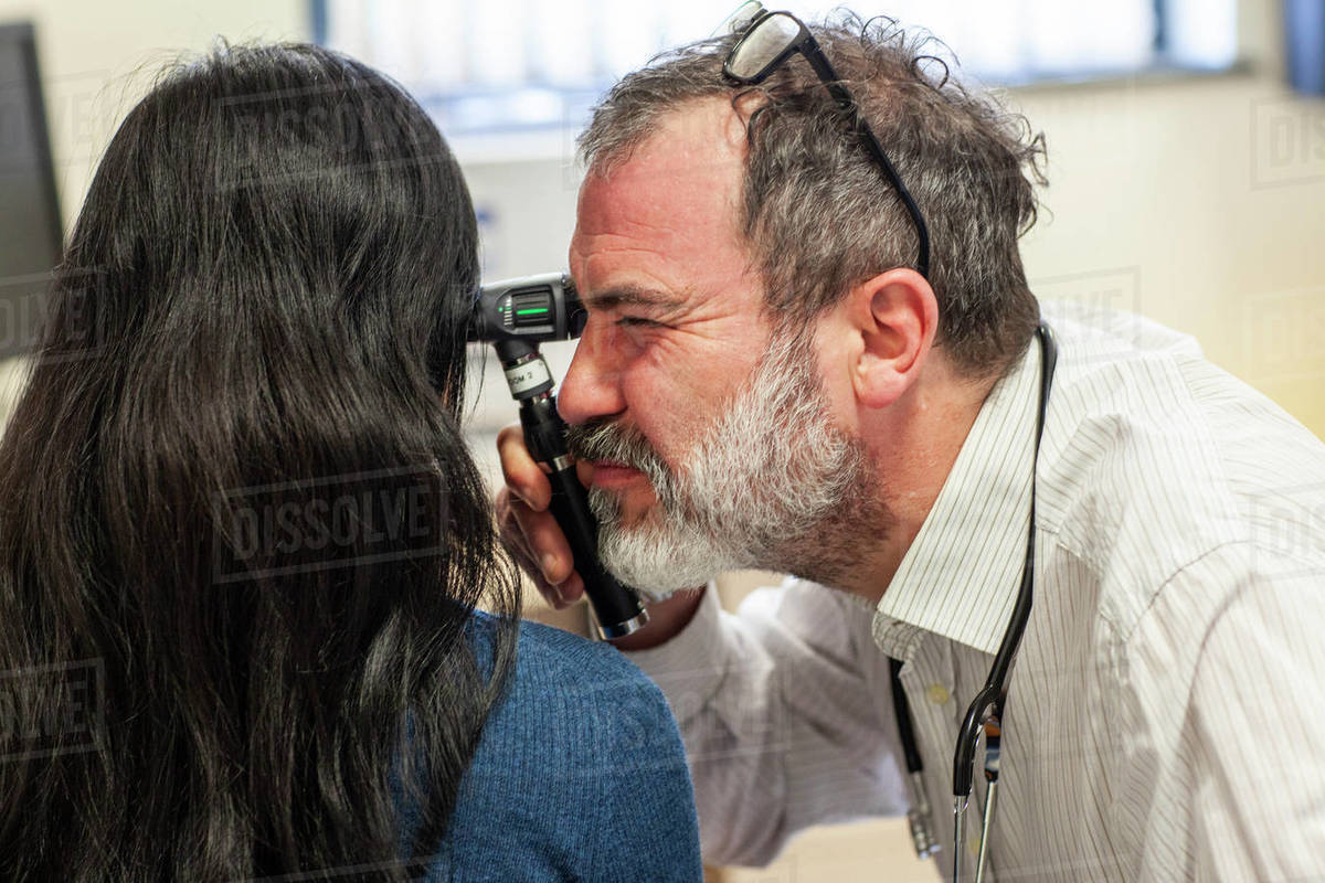 Doctor performing an ear exam in a medical practice - Royalty-free ...
