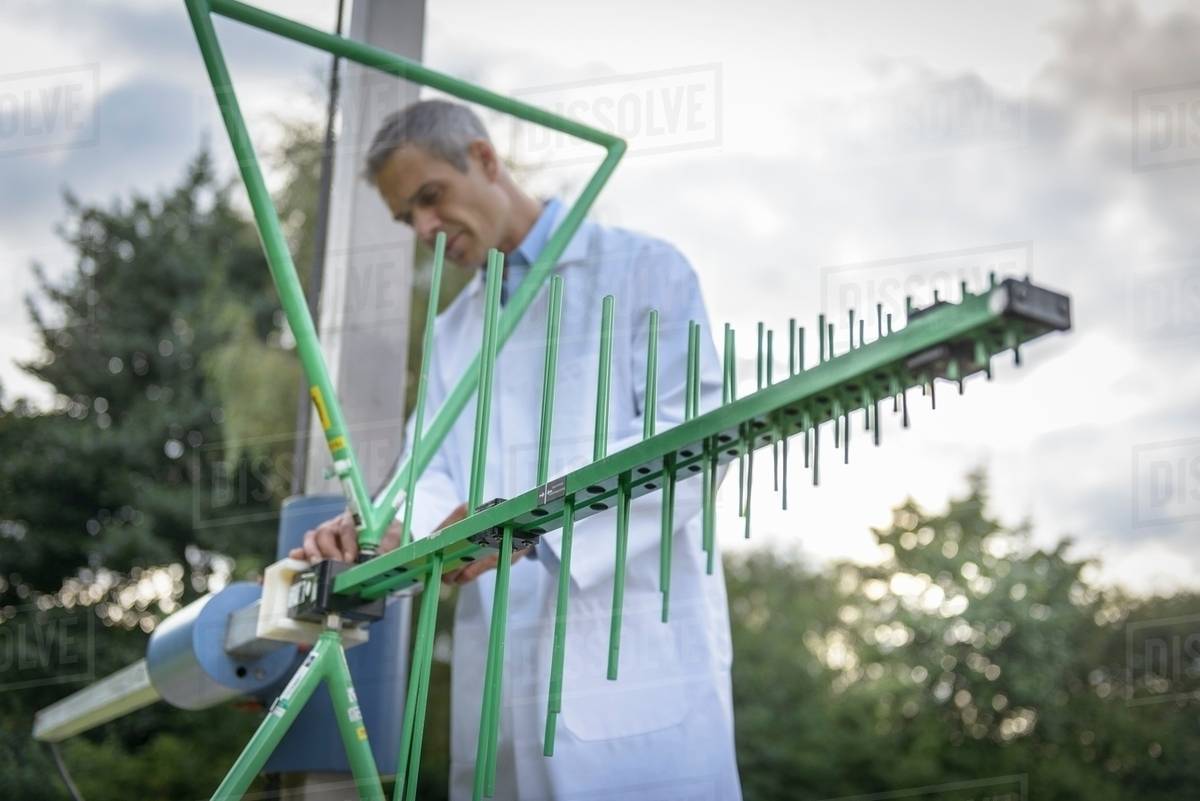 Scientist working outdoors with receiver aerial Stock
