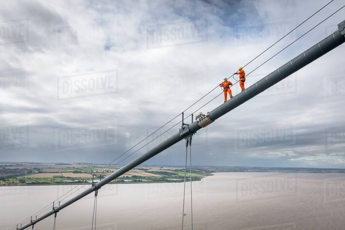 Bridge workers working on cable of suspension bridge. The Humber Bridge