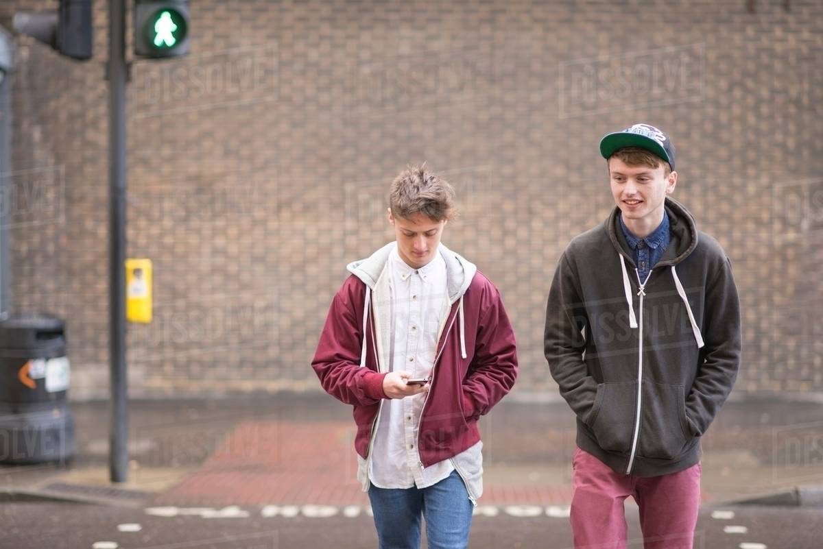 Two male friends crossing road Stock Photo Dissolve