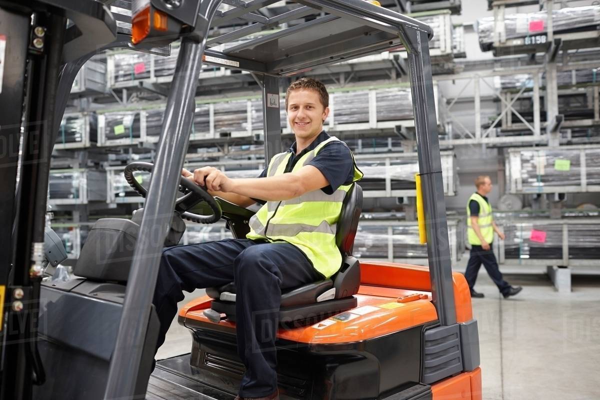 Forklift truck driver in engineering warehouse Stock Photo Dissolve
