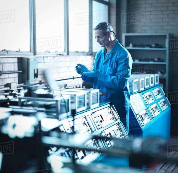 Worker testing spring in laboratory - Stock Photo - Dissolve