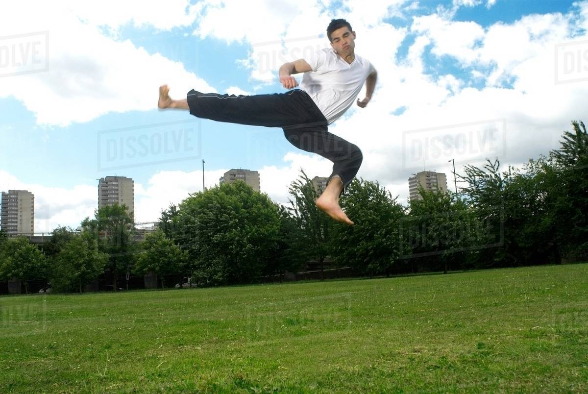 Jumping kick in park Stock Photo Dissolve